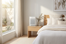 A bright modern Australian bedroom with soft natural sunlight, minimalist decor, clean aesthetic. A small compact air purifier placed on a bedside table next to a bed. 