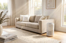 A bright Australian living room with soft natural sunlight, featuring the Levoit air purifier near a neutral-toned sofa. 